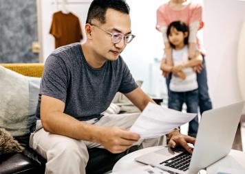 Man working on application while family watches