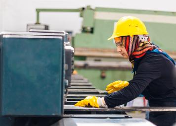 Muslim female worker working on cutting machine