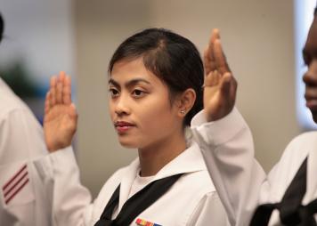 Asian Navy service woman pledging at a naturalization ceremony