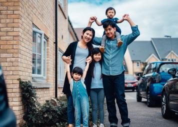 Asian family standing together, mom, dad, and three kids