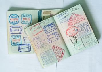 Color image of two open passports filled with customs stamps