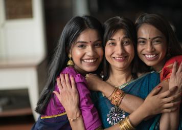 Retrato de una mujer india abrazando a sus hijas
