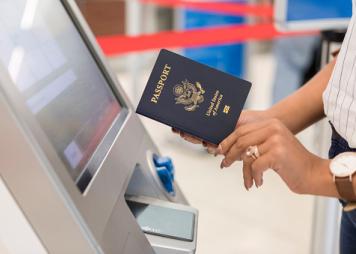 Woman uses automated passport control kiosk 