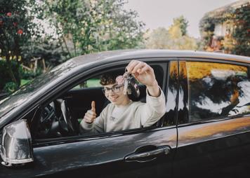 Boy inside car with new driving license