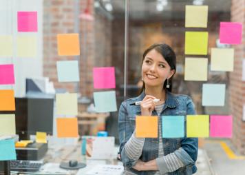 Mujer que plasma sus ideas en notas adhesivas