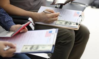 personas que llenan formularios de solicitud de inmigración a los Estados Unidos con pasaportes personales
