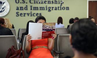 Una mujer sostiene un libro de estudio para el examen de ciudadanía estadounidense