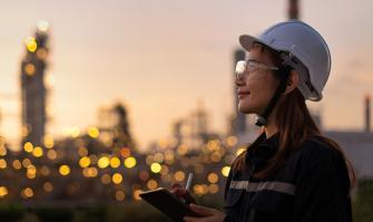 Una mujer asiática con casco y guantes inspecciona luces