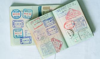 Imagen en color de dos pasaportes abiertos repletos de sellos de aduanas