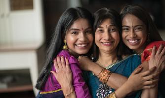 Retrato de una mujer india abrazando a sus hijas