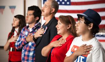 Hispanic family pledging allegiance to the American flag