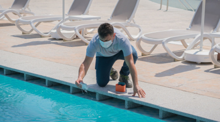 A man testing the PH levels at a pool