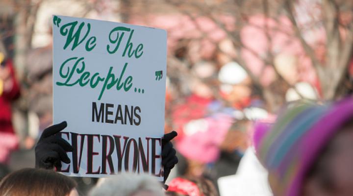 Cropped Hands Holding a sign saying We The People Means Everyone