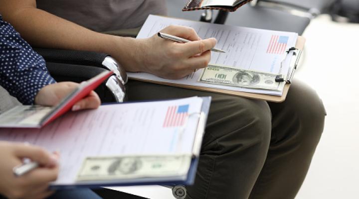 people filling usa immigration application forms with personal passports