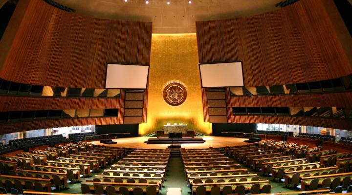 Foto del salón de la Asamblea General de las Naciones Unidas, una gran sala con colores dorados y verdes