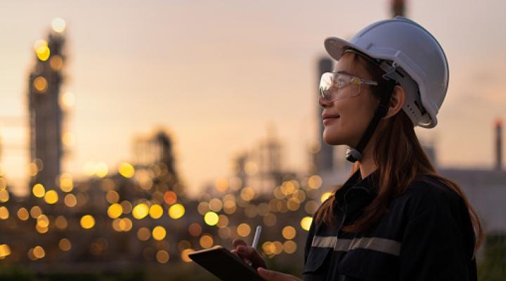 An Asian woman wearing a helmet and goggles inspects lights