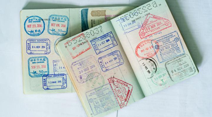 Color image of two open passports filled with customs stamps