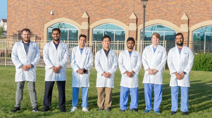 Estudiantes de medicina de la Facultad de Medicina y Ciencias de la Salud de la Universidad de North Dakota posando con su bata de laboratorio
