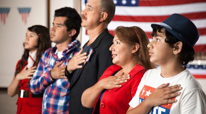 Una familia hispana jurando lealtad a la bandera estadounidense