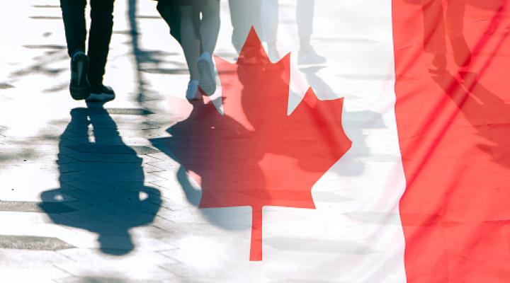 La bandera nacional de Canadá y sombras de personas