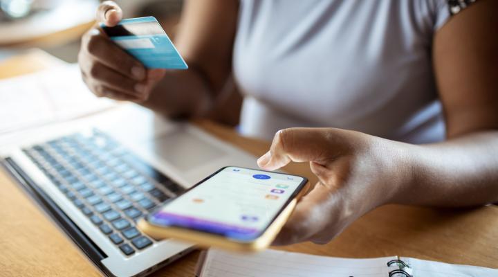 Close up of a mid adult woman using a banking app on her phone