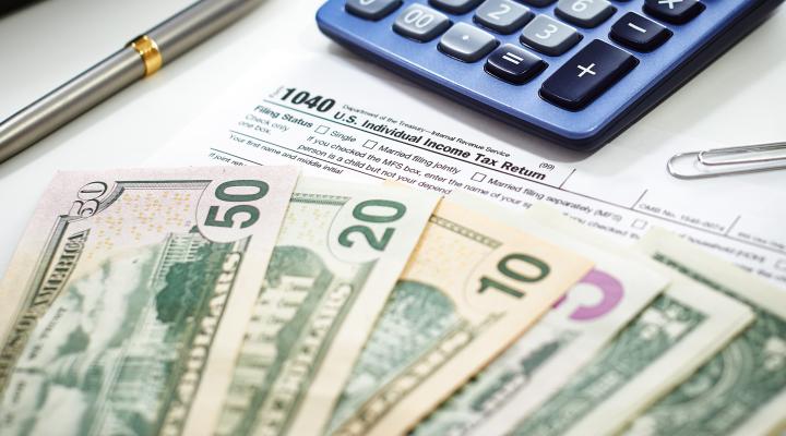 Moneda estadounidense con calculadora, concepto de contabilidad, dinero, negocios, impuestos, gastos mensuales y finanzas personales.