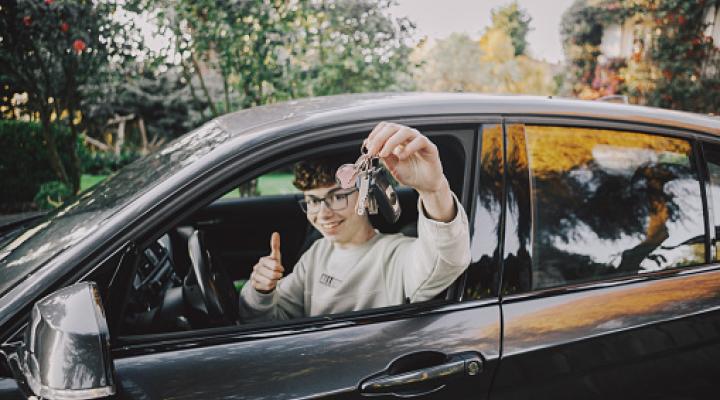 Boy inside car with new driving license