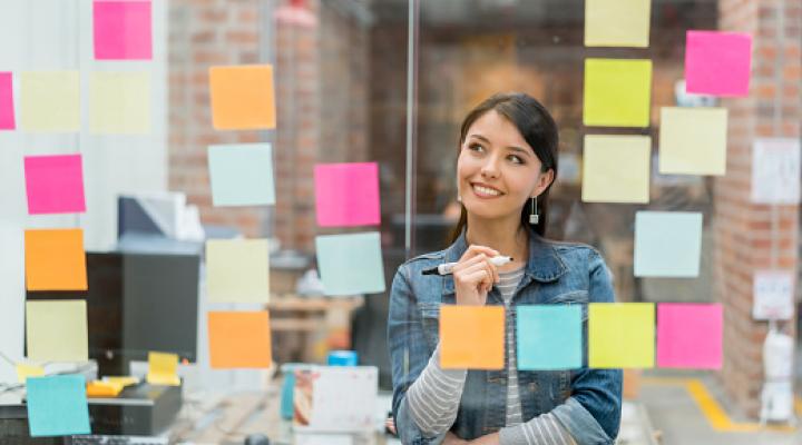 Woman brainstorming ideas using post-it notes