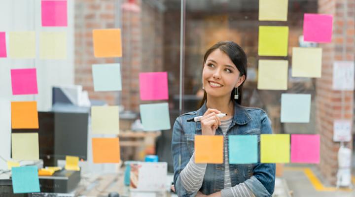 Mujer que plasma sus ideas en notas adhesivas