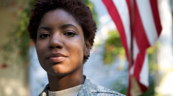 Military woman standing in front of American flag
