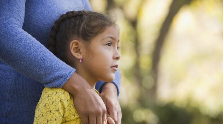 Young girl holding mothers hands